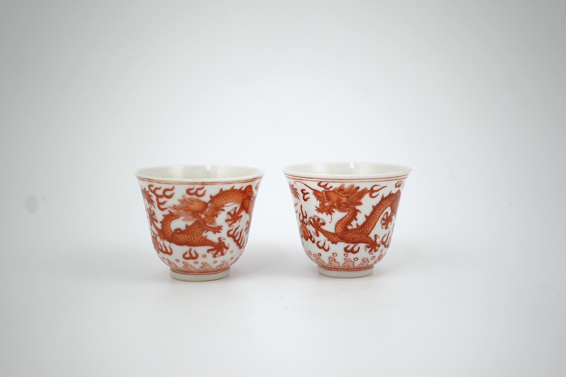 A pair of Chinese iron red ‘dragon’ cups, Guangxu six character mark and probably of the period (1875-1908)